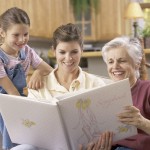 Girl with her mother and grandmother looking at a photo album